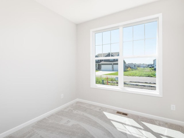 unfurnished room featuring light carpet and a wealth of natural light