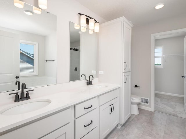 bathroom featuring vanity, tile patterned floors, toilet, and walk in shower