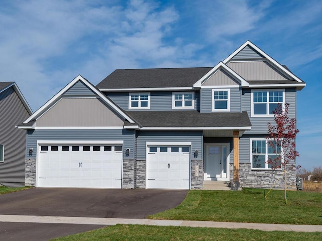 craftsman-style house with driveway, an attached garage, a shingled roof, and a front yard