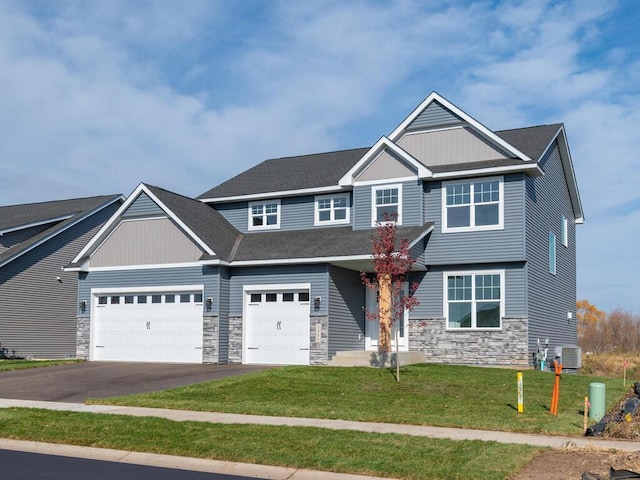 craftsman house with a garage, a front lawn, and central air condition unit