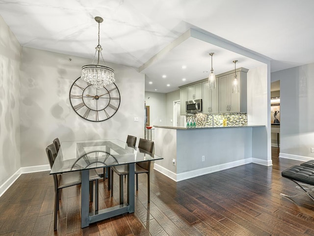 kitchen featuring dark hardwood / wood-style flooring, decorative light fixtures, and kitchen peninsula