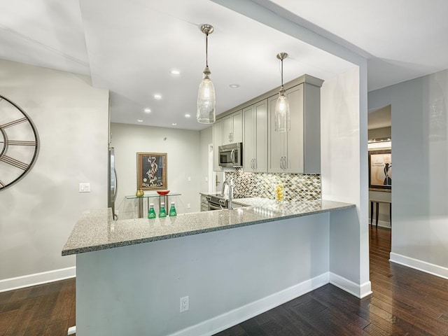 kitchen with appliances with stainless steel finishes, decorative light fixtures, gray cabinetry, kitchen peninsula, and light stone countertops