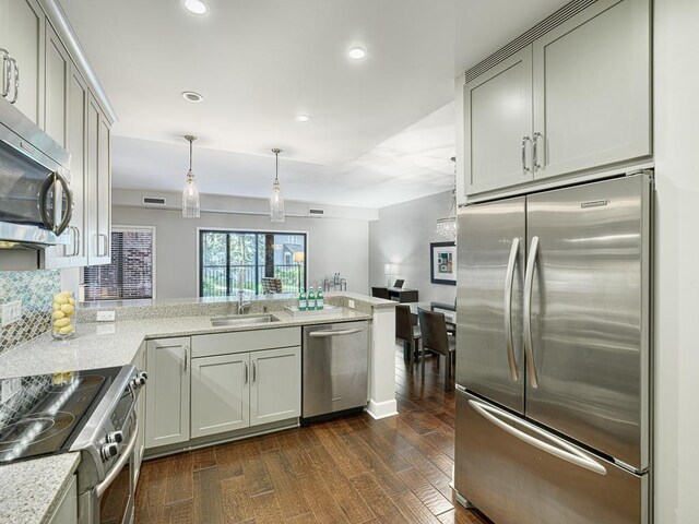 kitchen featuring sink, dark wood-type flooring, stainless steel appliances, and light stone countertops