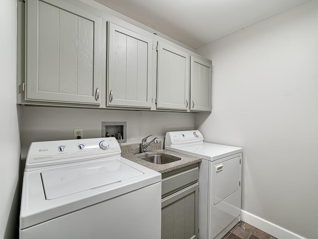 laundry area featuring cabinets, sink, and washer and clothes dryer