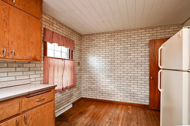 kitchen with brick wall, dark hardwood / wood-style floors, and white refrigerator