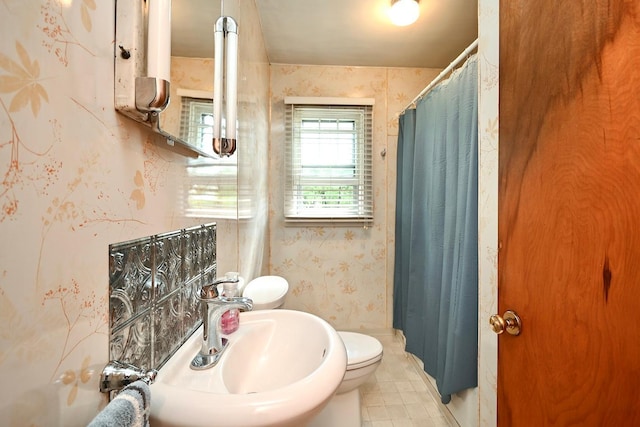 bathroom featuring walk in shower, toilet, and sink