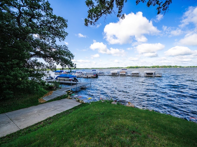 view of dock featuring a water view and a yard