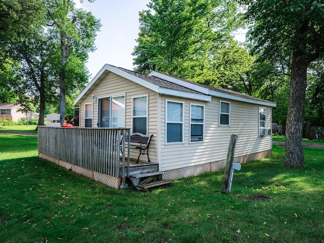 rear view of house with a wooden deck and a yard