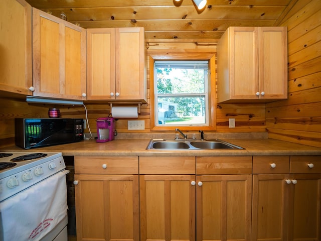 kitchen with wooden walls, sink, white stove, and light brown cabinetry