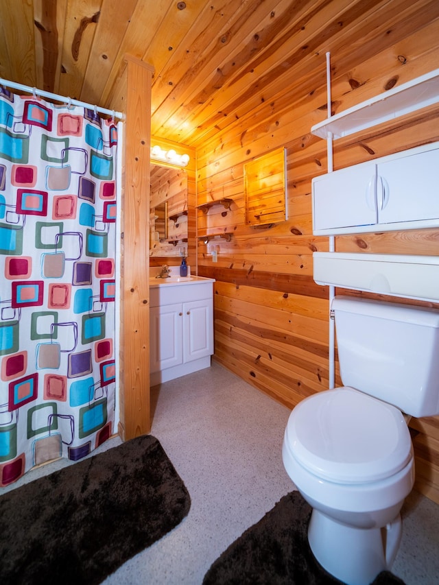 bathroom with wooden ceiling, vanity, wood walls, and toilet