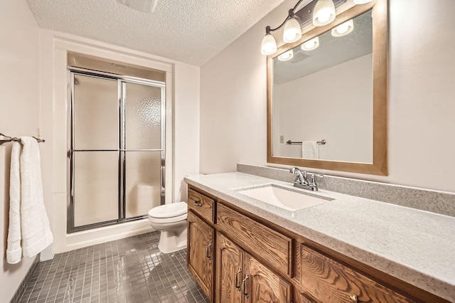full bath featuring tile patterned flooring, vanity, toilet, a textured ceiling, and a shower stall