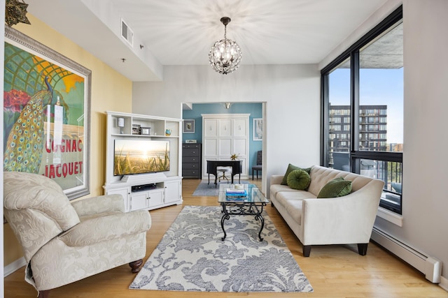 living room with light wood-type flooring, expansive windows, a baseboard heating unit, and a chandelier