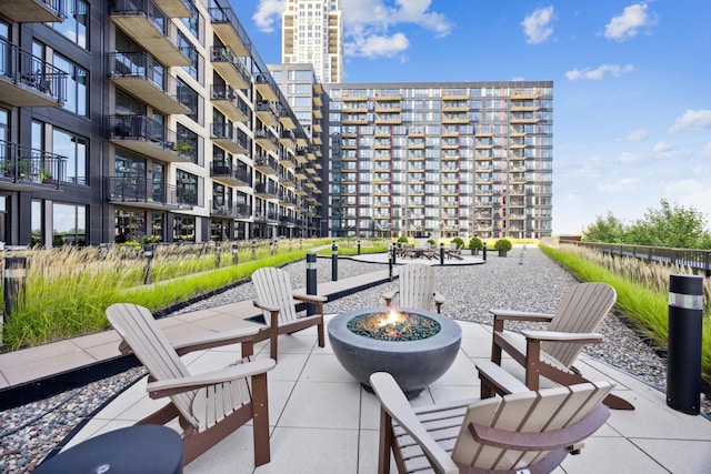 view of property's community featuring a fire pit, a patio area, and a view of city