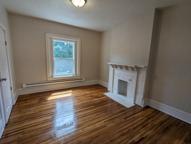 unfurnished living room with a baseboard heating unit, baseboards, hardwood / wood-style floors, and a fireplace