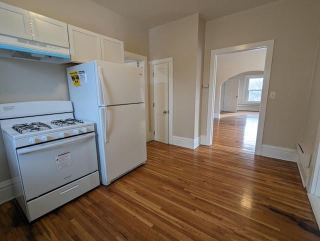 kitchen with under cabinet range hood, white appliances, white cabinets, and hardwood / wood-style flooring