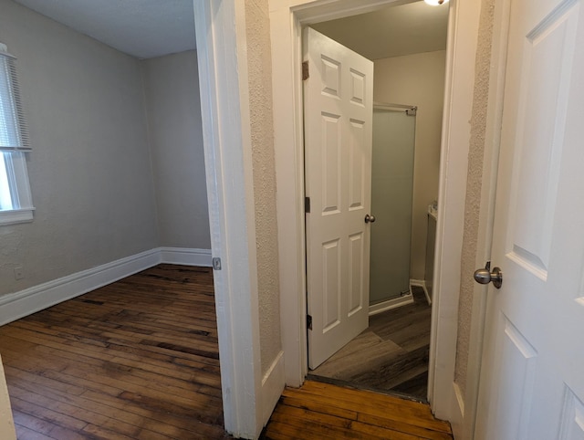 hall featuring baseboards and hardwood / wood-style floors