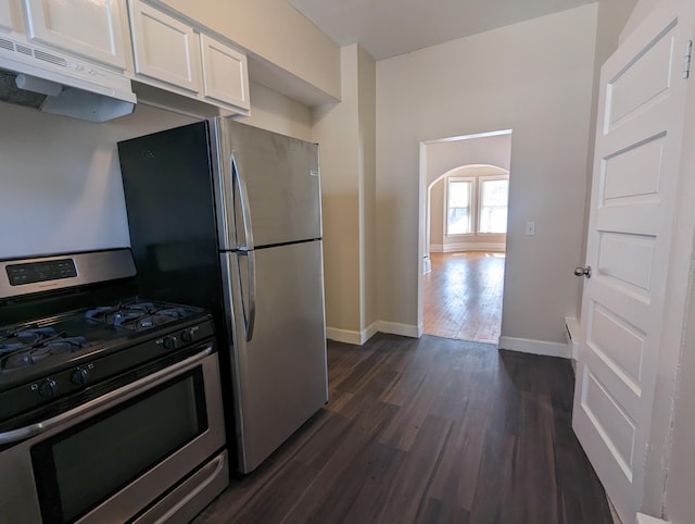 kitchen with arched walkways, stainless steel appliances, dark wood-type flooring, white cabinets, and under cabinet range hood