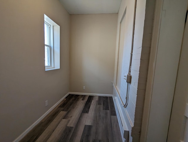 interior space featuring baseboards and dark wood-style flooring