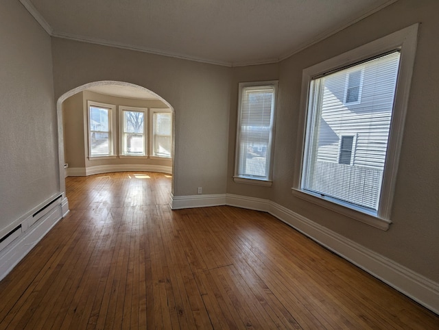 unfurnished room with a baseboard radiator, hardwood / wood-style flooring, arched walkways, and ornamental molding