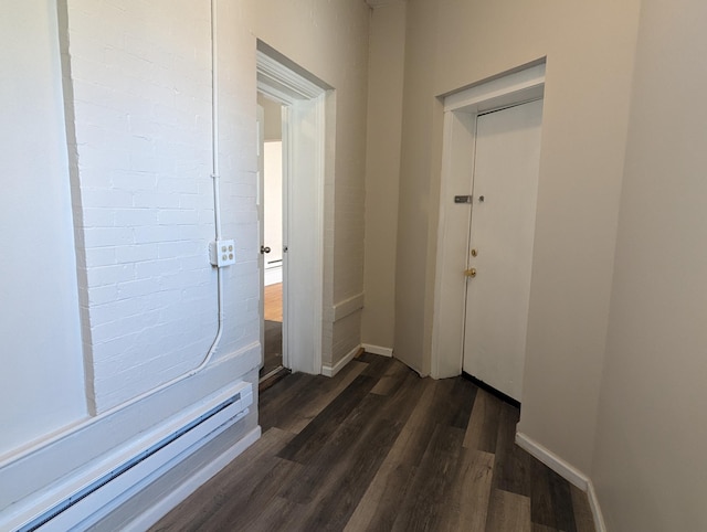 hall with dark wood-style floors, baseboard heating, and baseboards