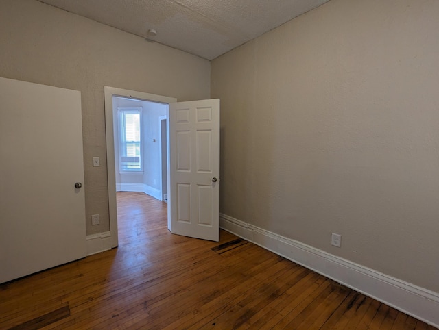 unfurnished room featuring baseboards and wood-type flooring