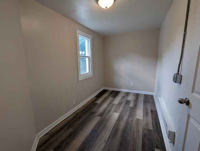 unfurnished room with dark wood finished floors and baseboards