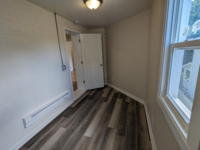 unfurnished room with baseboards, baseboard heating, and dark wood finished floors