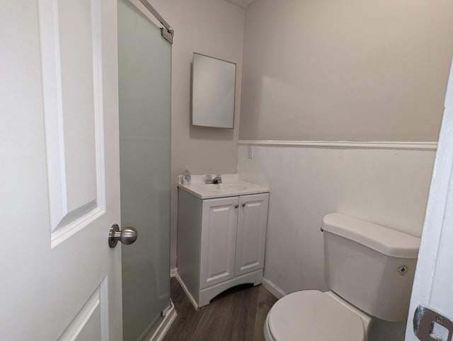 full bath featuring a shower, toilet, wood finished floors, and vanity