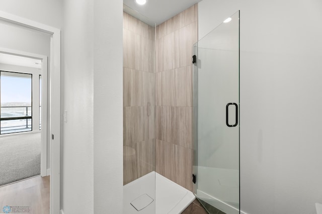 bathroom featuring hardwood / wood-style flooring and a shower with door