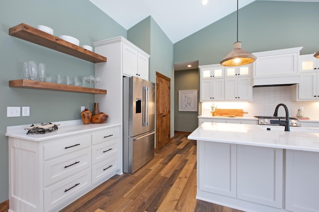 kitchen featuring dark wood-type flooring, white cabinetry, high end refrigerator, hanging light fixtures, and decorative backsplash