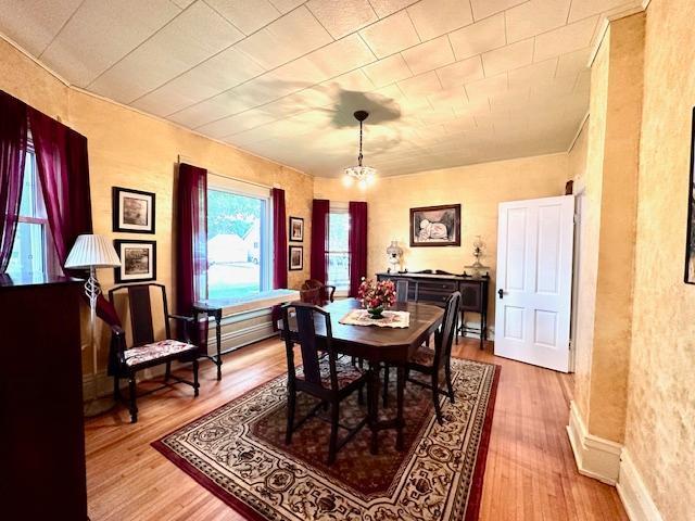 dining space with light hardwood / wood-style flooring and an inviting chandelier