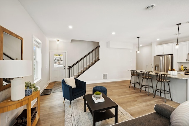 living room with sink and light hardwood / wood-style floors