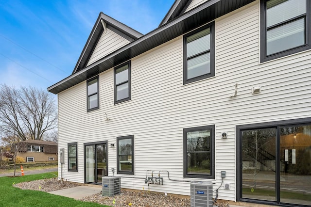 back of property with central AC unit and a patio