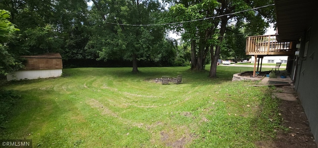 view of yard featuring a deck and a storage unit