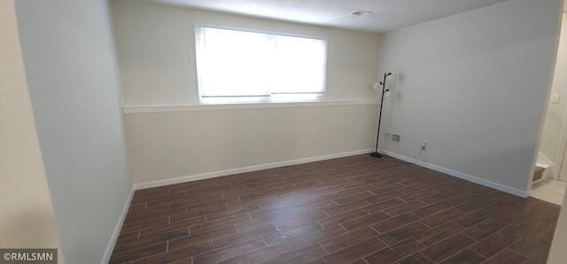 empty room with dark hardwood / wood-style flooring