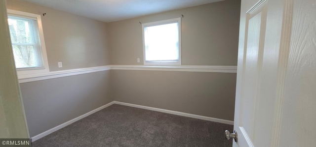 carpeted spare room featuring a wealth of natural light and baseboards