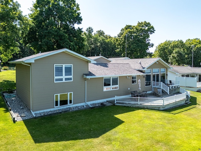 rear view of house with a deck and a lawn