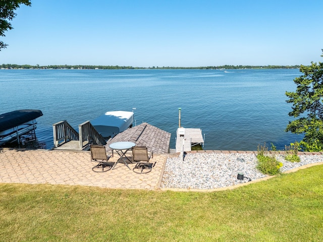 view of dock featuring a water view and a yard