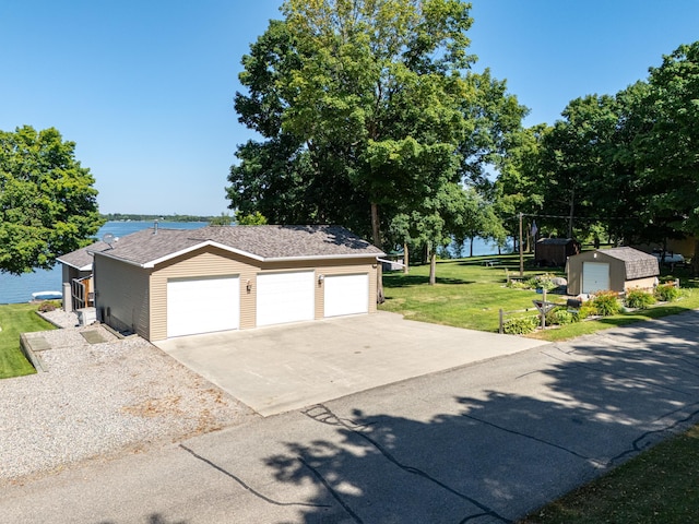 garage featuring a lawn and a water view