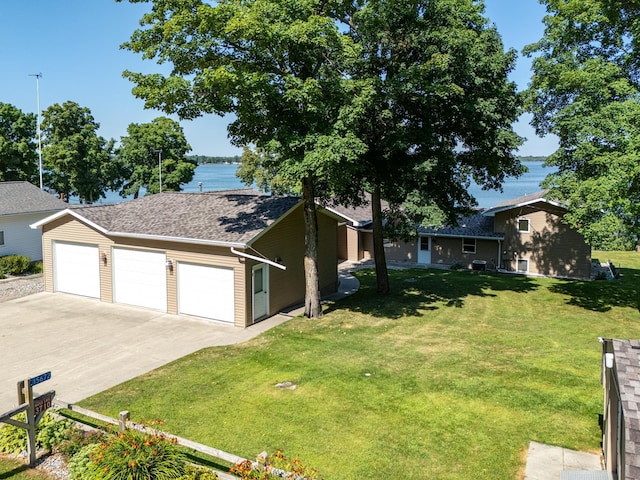 exterior space featuring a front lawn, a water view, and a garage