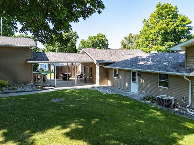 back of house featuring cooling unit, a lawn, and a patio