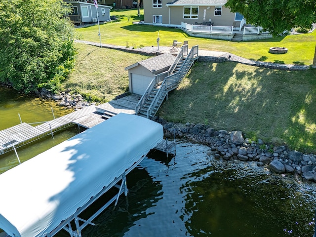 dock area with a lawn, a water view, and a fire pit