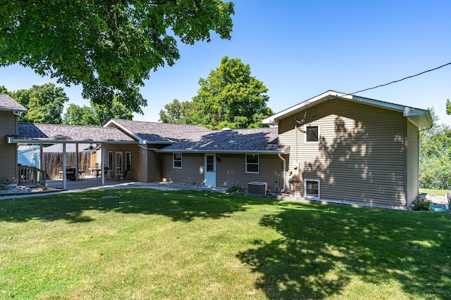 rear view of property with central AC, a patio area, and a lawn