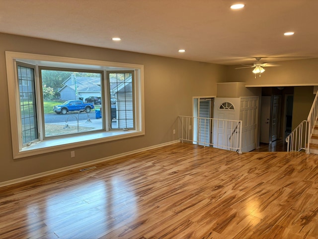 unfurnished living room with ceiling fan and light hardwood / wood-style flooring