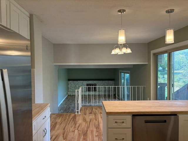 kitchen featuring white cabinetry, butcher block counters, and stainless steel refrigerator