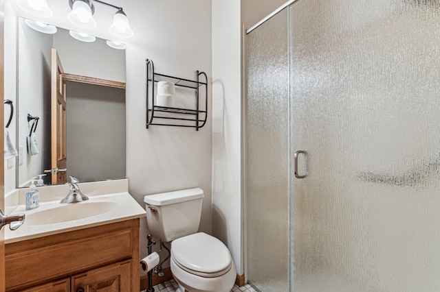 bathroom with vanity, toilet, and a shower with door