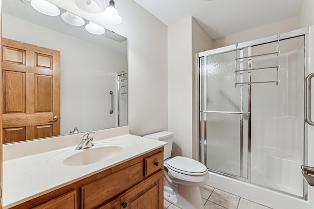 bathroom with tile patterned flooring, vanity, toilet, and an enclosed shower