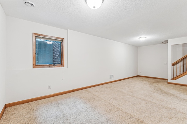 carpeted empty room featuring a textured ceiling