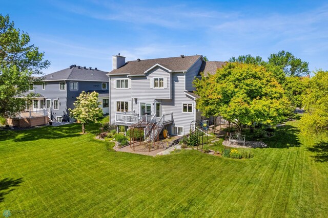 rear view of house with a lawn and a wooden deck