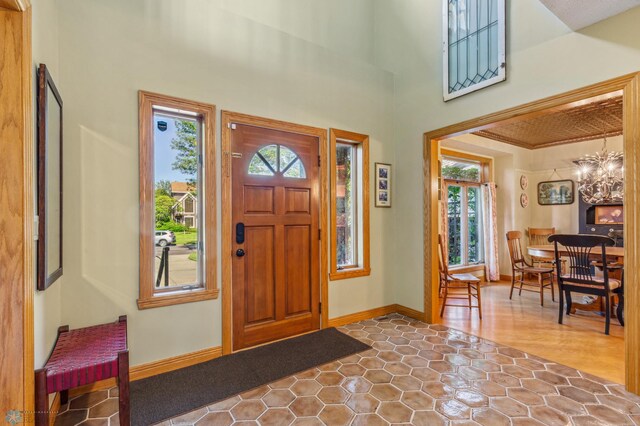 foyer entrance with a towering ceiling, a notable chandelier, and tile patterned flooring